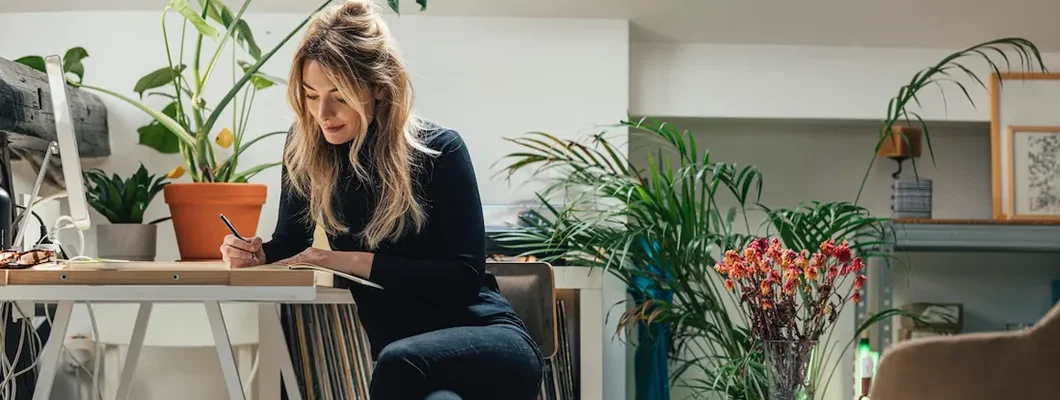 Businesswoman Sitting At Her Desk At Home And Working. How to Write a Business Plan.