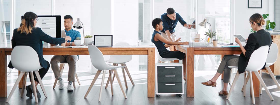 Team of businesspeople working together in a modern office. Find Employment Practices Liability Insurance.