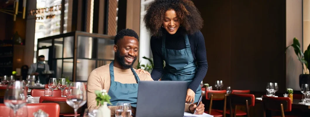 Restaurant managers working with laptop. Find Morrisville, North Carolina business insurance.