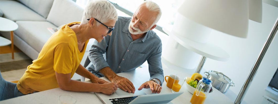 Mature couple buying some goods online. Find Variable Annuities.