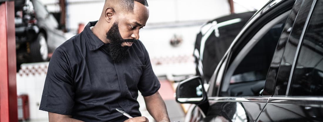 Mechanic inspecting car. Maryland Garage Keepers Insurance.