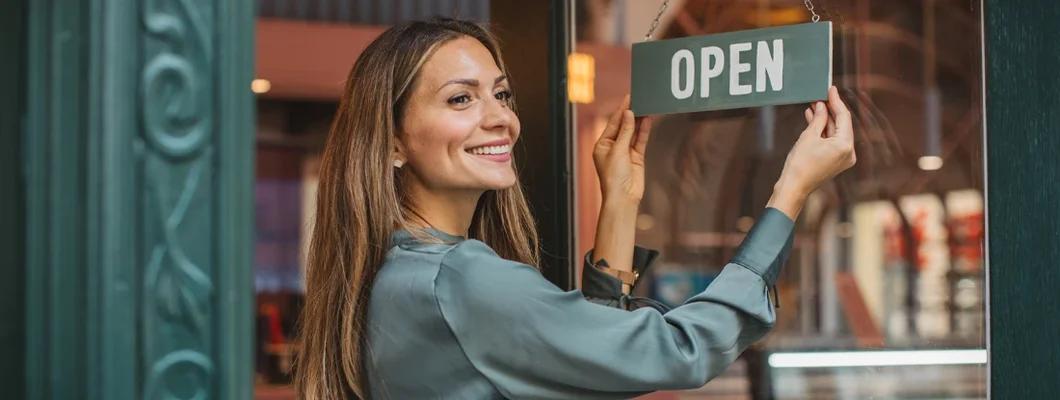Young woman opening her store and waiting for customers. Waukee, Iowa Business Insurance. 