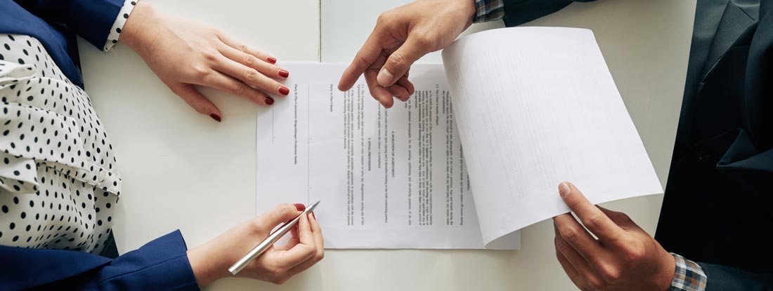 Woman signing contract at meeting, view from above. Find Notary Insurance.