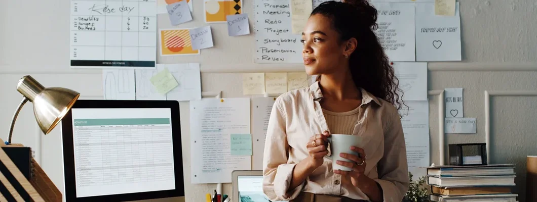 Businesswoman standing while holding a cup of coffee in her office. How to Find the Best Business Insurance in Garden City, New York.