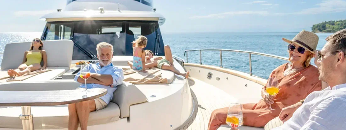 Family enjoying cruise on yacht on sunny day. Find Boat Liability Insurance.