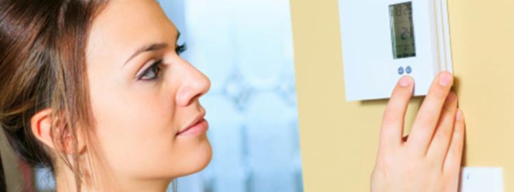woman checking thermostat