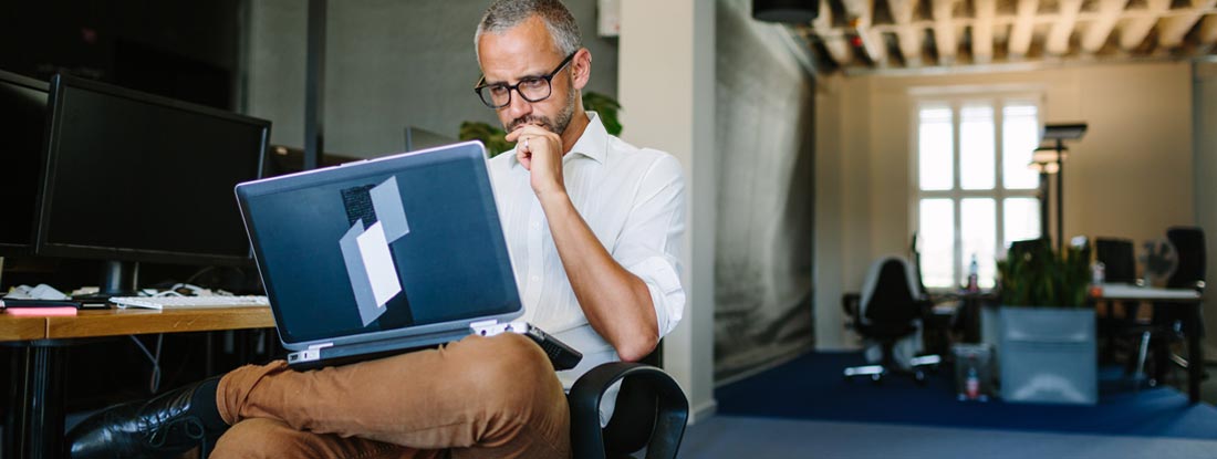 Businessman busy working on laptop. Workers Compensation Exemption.