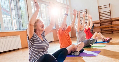 Cheerful seniors doing yoga together. Find life insurance.