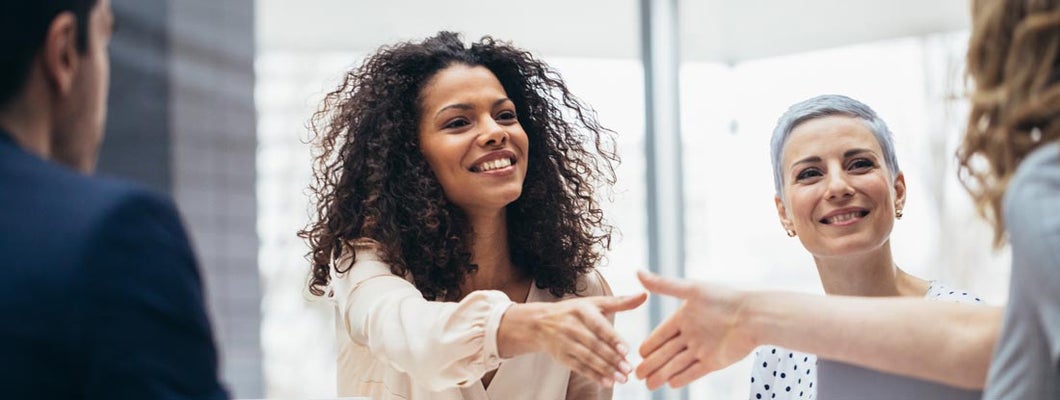 Businesswomen shaking hands with new hire at the office