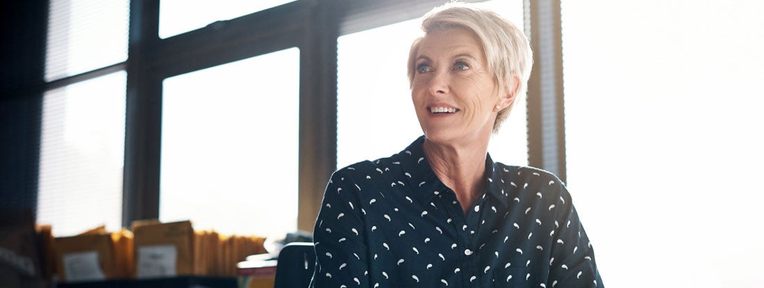 Businesswoman with short blonde hair in an office setting. Market Value Adjusted Annuity.