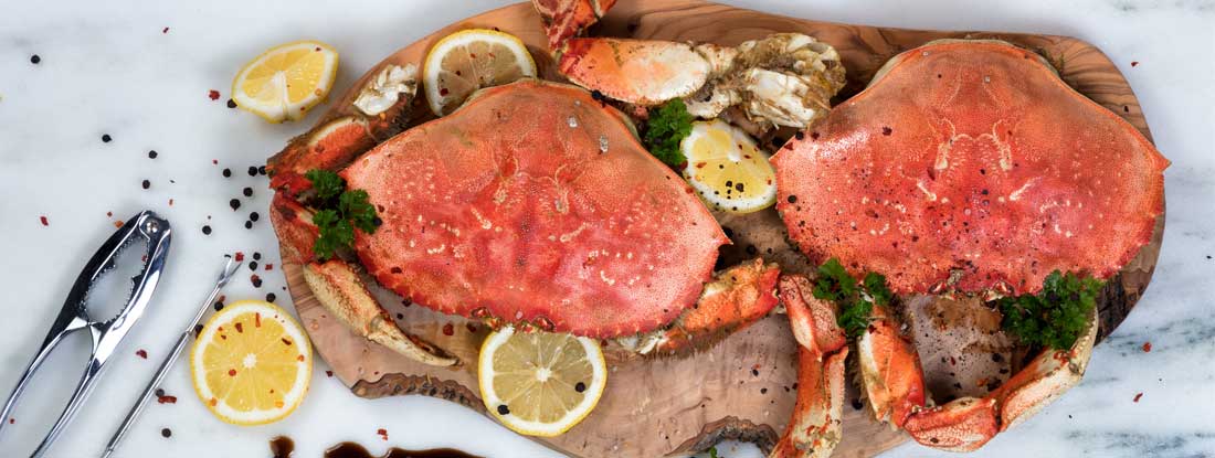 Freshly cooked crab with spices on wooden server. Oregon Restaurant Insurance. 