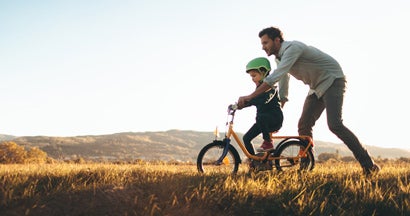 Father teaching son to ride a bike. Get term life insurance quotes.