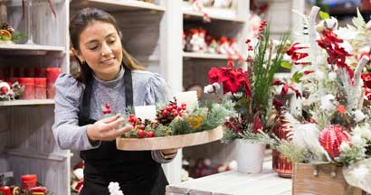 Flower shop worker making christmas compositions. How to prepare your small business for the holidays.