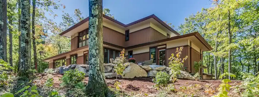 Beautiful clear day and a home surrounded by tall skinny trees. Jackson, Wyoming Homeowners Insurance. 