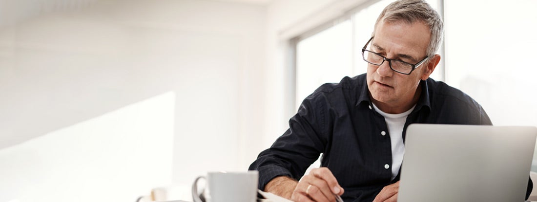 Man going through annuity paperwork at home. Variable Annuity IRA.