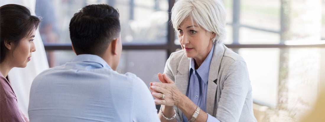 A counselor discusses advice to attentive couple. Find Social Work Malpractice Insurance.
