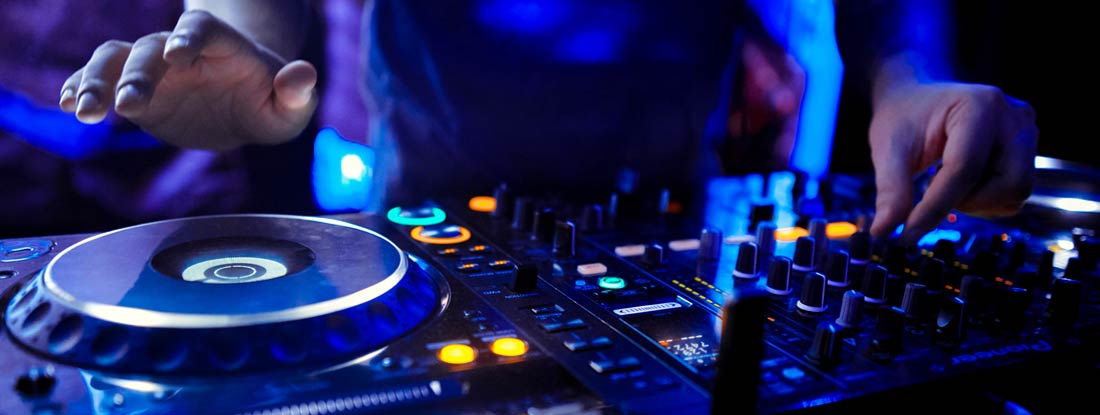 Dj mixes the track in the nightclub at party. Find DJ Insurance.