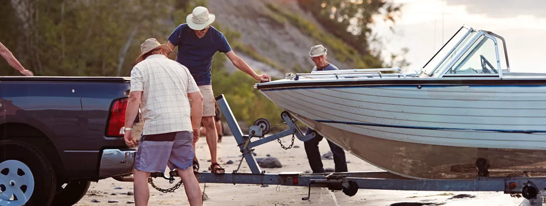 Stacking boat and lashing it onto a trailer. Find Tennessee Trailer Insurance.