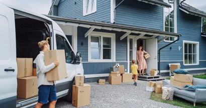 Family Moving to Their New Home in Residential Area. When to Buy a House: How Seasons Affect Home Prices.