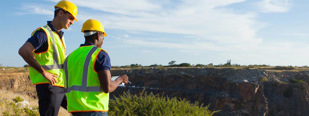 two geophysical surveyors working at mining site