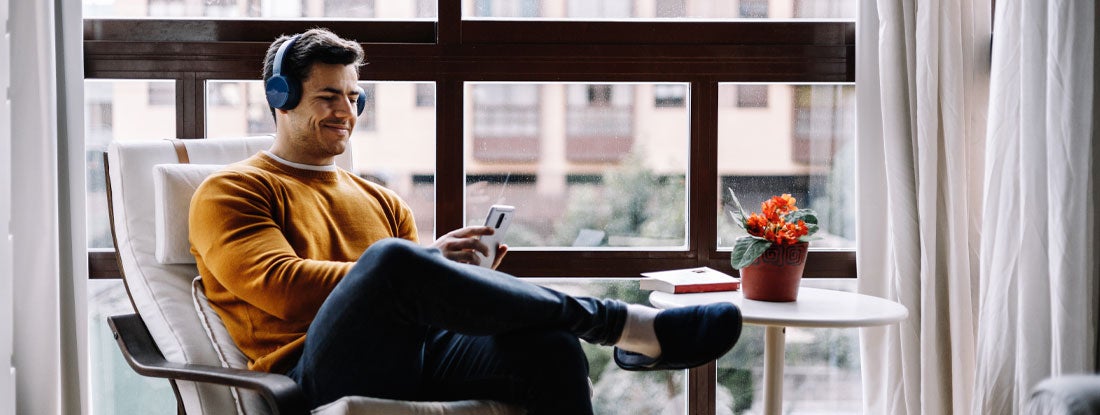 Man with headphones enjoying music in Minnesota condo. Find Minnesota condo insurance.
