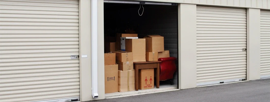 Self storage warehouse with single storage unit open. Why you need insurance for property in storage. 