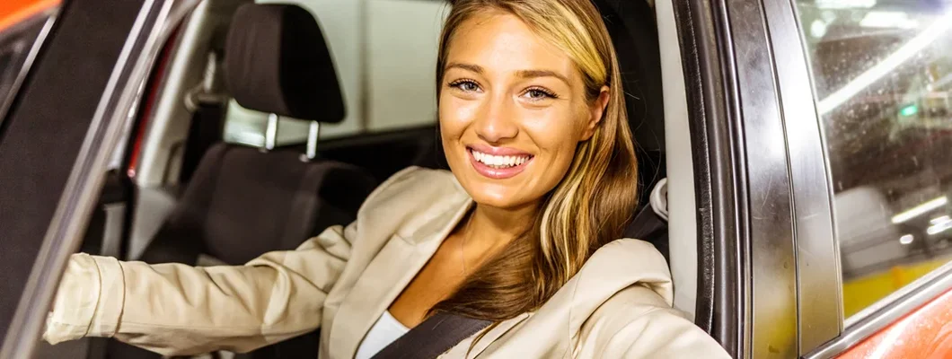 Woman driving in car to work with her arm leaning out of the vehicle during the day. How to Find the Best Car Insurance in Swarthmore, Pennsylvania. 
