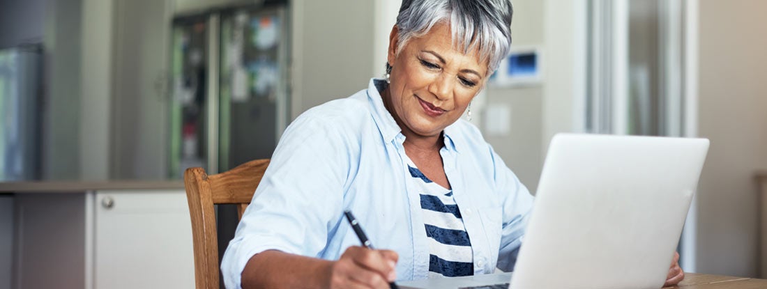 Senior woman using a laptop to do the household finances. The Complete Guide to Annuity Rates.