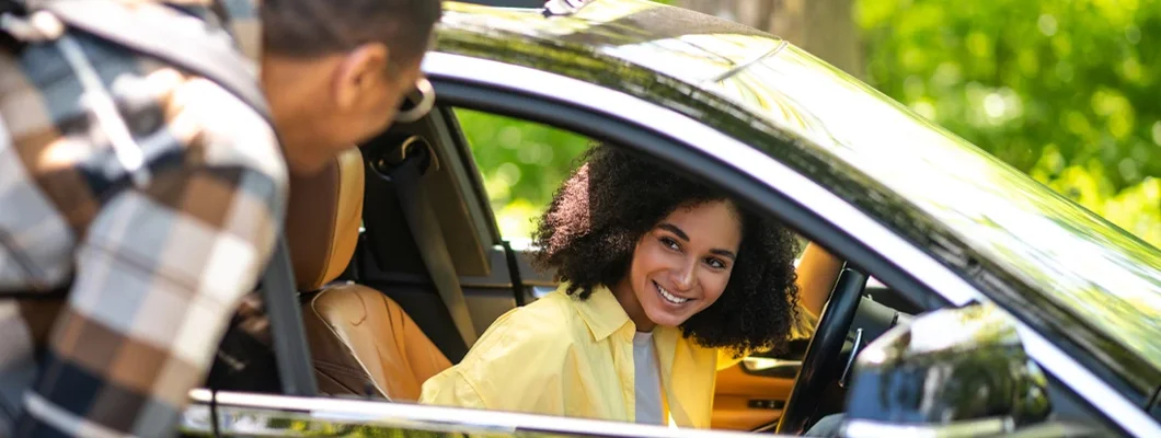 Young man talking to female driver while asking the way. Middleton, Wisconsin Car Insurance. 