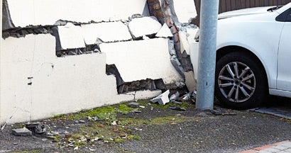 Smashed wall and damaged car in the aftermath of a traffic accident. Car damage to property.