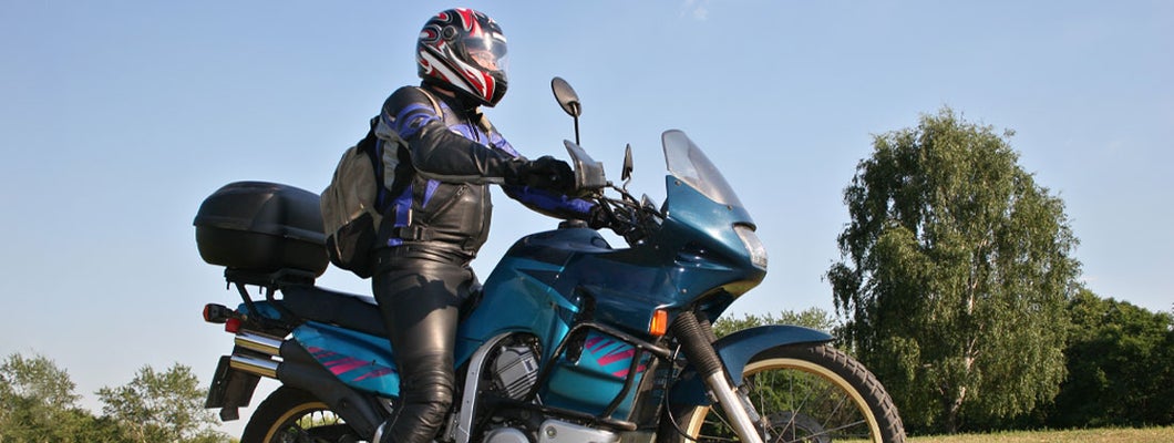 Man with helmet riding custom motorcycle. Find Raleigh, North Carolina motorcycle insurance.