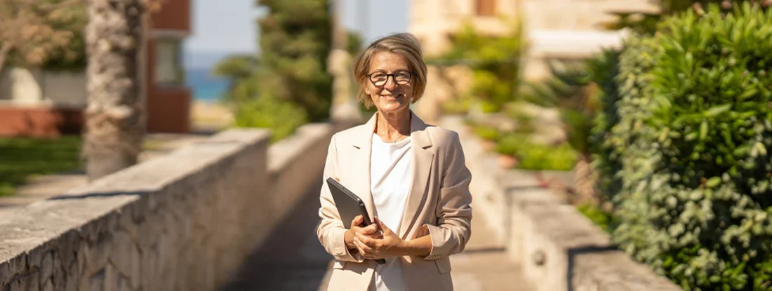 Real estate agent waiting clients in front of of apartments in coastal town. Find Landlord Insurance Cost. 