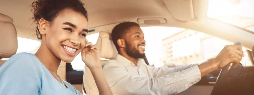 Couple driving in car, traveling together. Find Northbrook, Illinois car insurance.