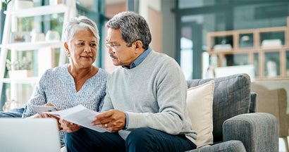 Mature couple going through paperwork together at home. How to buy long term care insurance.