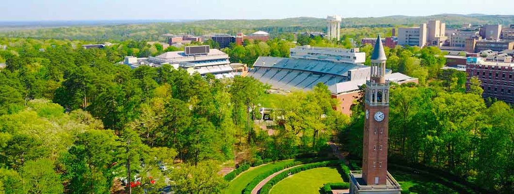 Aerial shot at UNC of the campus bell tower and football stadium.