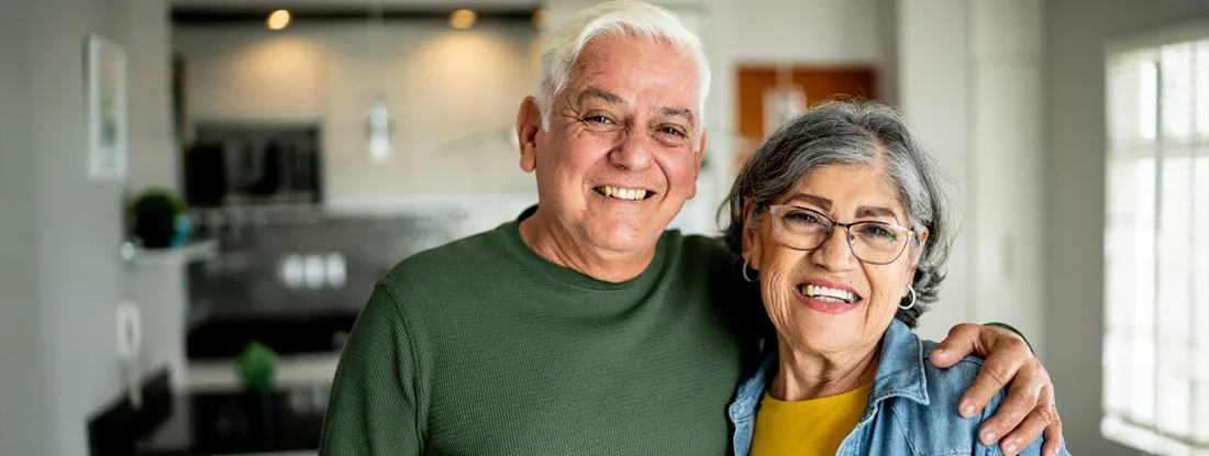 Senior couple embracing at home. Selling Life Insurance Policy.