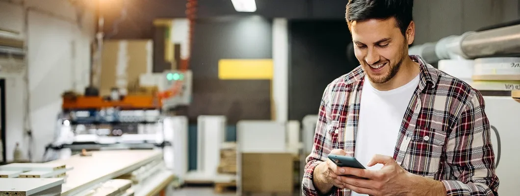 Smiling Carpenter Using Phone. Business Insurance in Elko, Nevada.