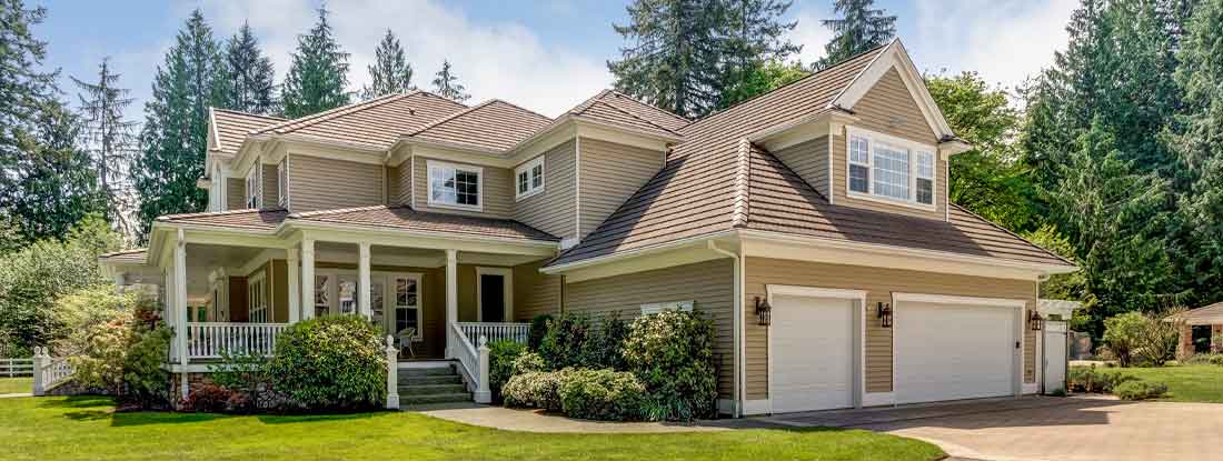 Two-story residential house situated in a wooded area. Homeowners insurance near you.