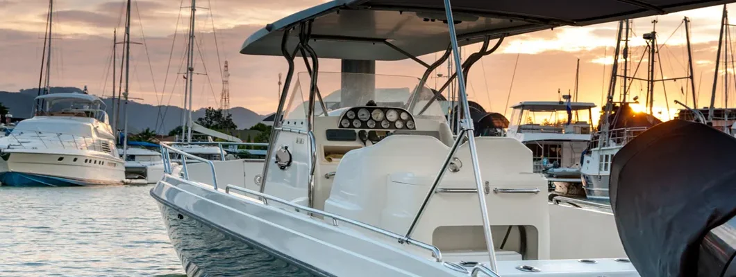 Small motorboat docking at the marina at sunset time. Find Washington Boat Insurance.