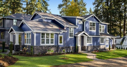 Beautiful home exterior on bright sunny day with green grass and blue sky. Find Home Insurance Discounts.