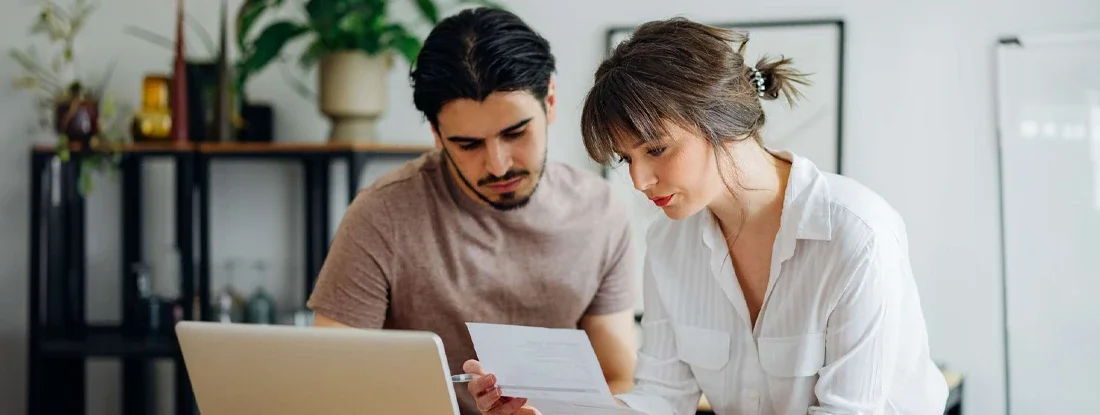Couple doing home finances together online in the kitchen. What Is SR-22 Insurance and How Does It Work?