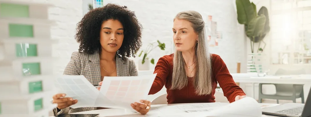 Team of designers reading documents together. How to Find the Best Business Insurance in Canby, Oregon.