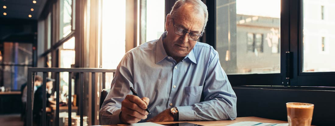 Mature businessman in cafe making notes. What Is a Standard Workers' Compensation Policy?