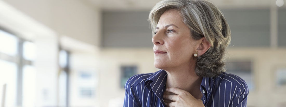 Woman sitting in an office environment with a laptop in front of her. Variable Annuity Pros and Cons.