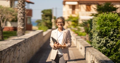 Real estate agent waiting clients in front of of apartments in coastal town. Find Landlord Insurance Cost. 