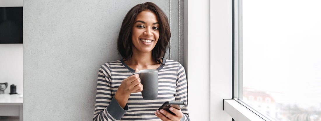 Smiling woman using mobile phone. Find Key Person Insurance.