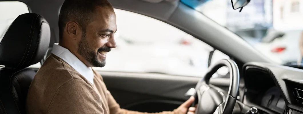 Man admiring new car in a showroom. How to Find Great Car Insurance at a Competitive Price in Mustang, OK. 