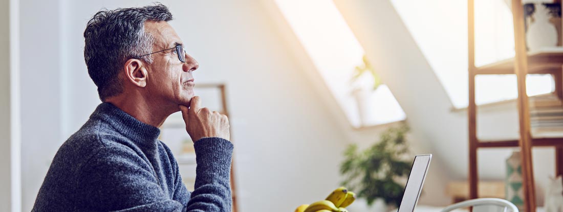 Mature man using a laptop at home. Variable annuities assumed interest rate.