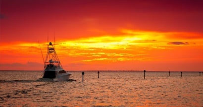 Large fishing boat going out for a sunset cruise in Destin, Florida. Find Alabama Boat Insurance.