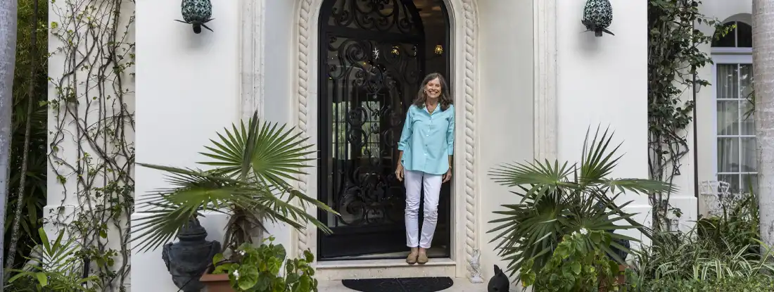 Woman standing in doorway of elegant home. How to Prepare to Rent Your Home.